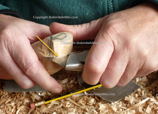 Rolling the knife at the lower part of the head.